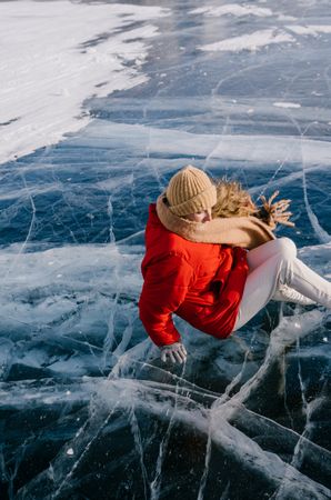 Happy woman in skates lying on ice