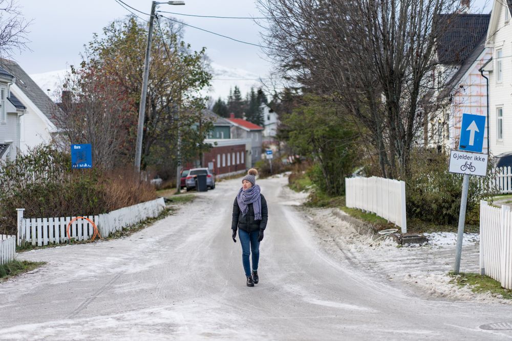Female tourist in warm wear exploring suburbs of city