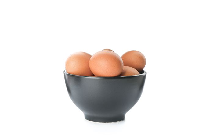 Brown chicken eggs in bowl isolated on plain background