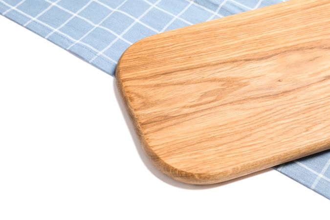 Cutting board with kitchen towel isolated on plain background
