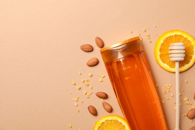 Shampoo bottle and natural ingredients on craft background. Blank space on bottle