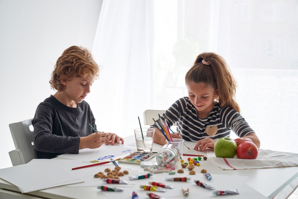 Children painting at messy table