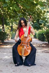 Woman playing the cello in a park.