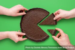 Pie chart concept, people sharing chocolate cake, above view on a green background bEqBVb