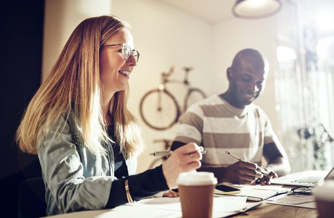 Male and female colleagues working in office with bikes
