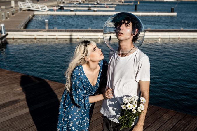 Woman hugging man with fish bowl on head