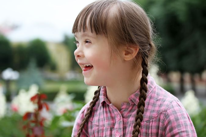 Laughing young girl with Down syndrome with her hair in braids