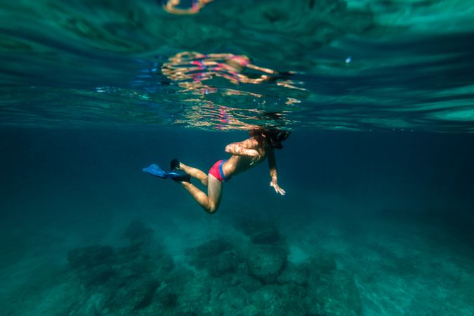 Crop preteen boy snorkeling in sea water with flippers