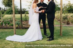 Couple standing before the priest for wedding ceremony outdoors in the park 5XepQ4
