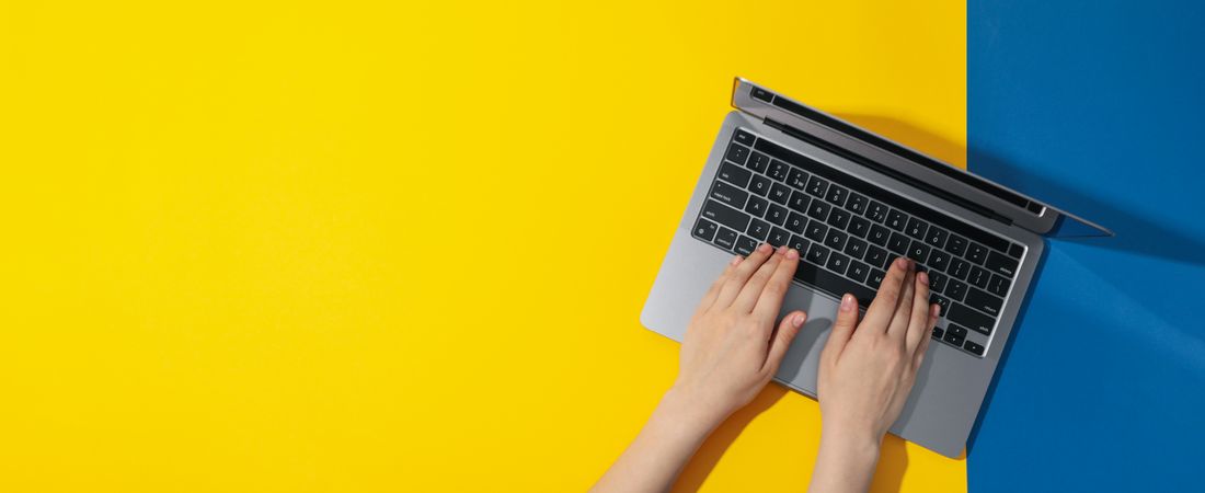 Top view banner of woman using laptop on yellow blue table