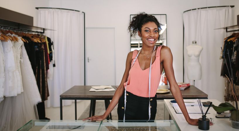 Female fashion designer standing at her desk in her boutique