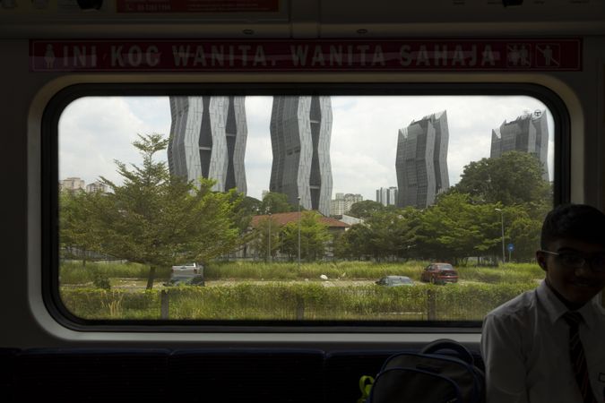 Window from inside the KTM train line, in Kuala Lumpur, Malaysia, heading towards Batu caves