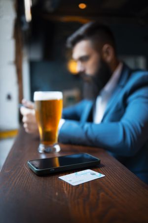 Man with pint of beer and smart phone