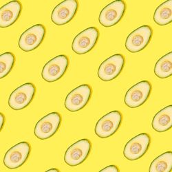 Cut avocado pattern on yellow background