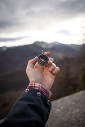 Traveler carrying compass in mountain valley