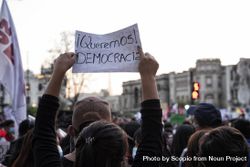 Person holding a banner with text saying " Queremos Democracia" at protest against unconstitutional Merino's Peruvian president 5X8DV5