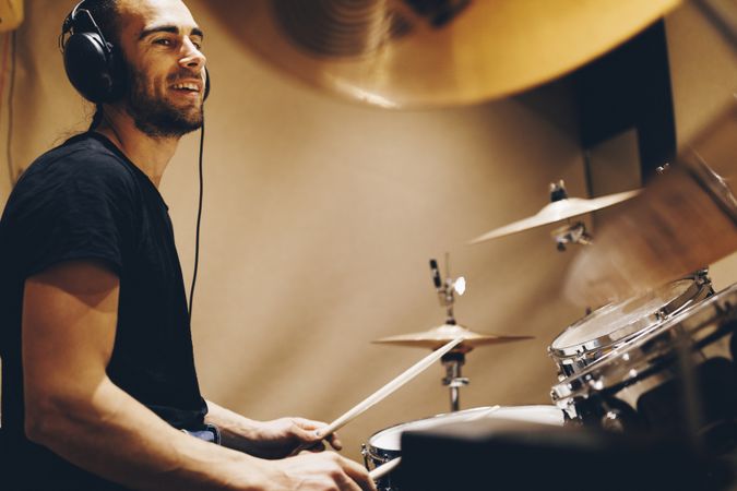 Man with headphones playing on drums