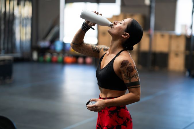 Side view of woman drinking from water bottle