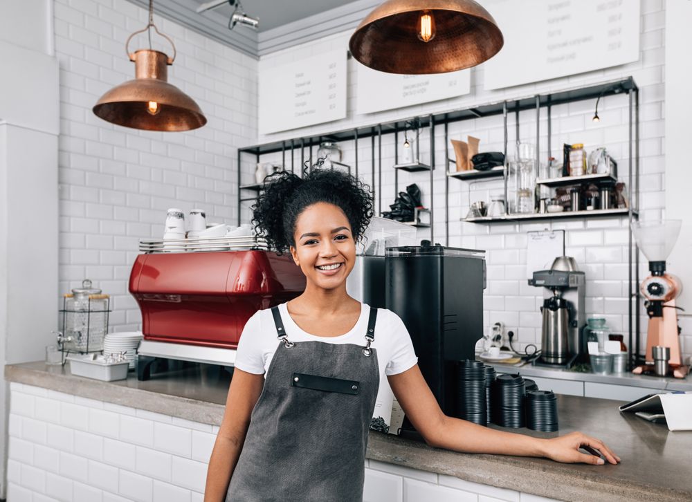 Proud cafe owner smiling at counter