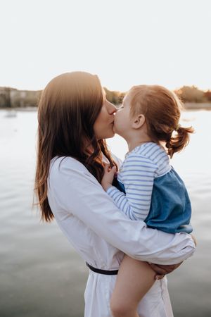 Mother and daughter standing near water