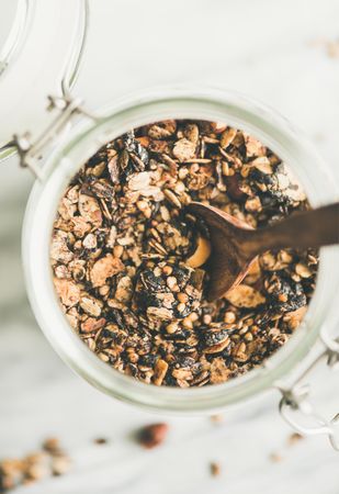 Top view glass container of homemade granola, close up