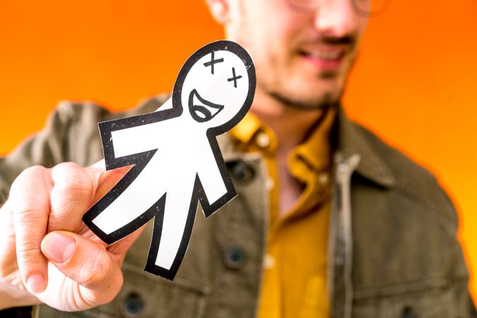 Smiling man holding funny paper toy