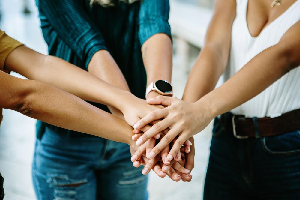 Women joining their hands together