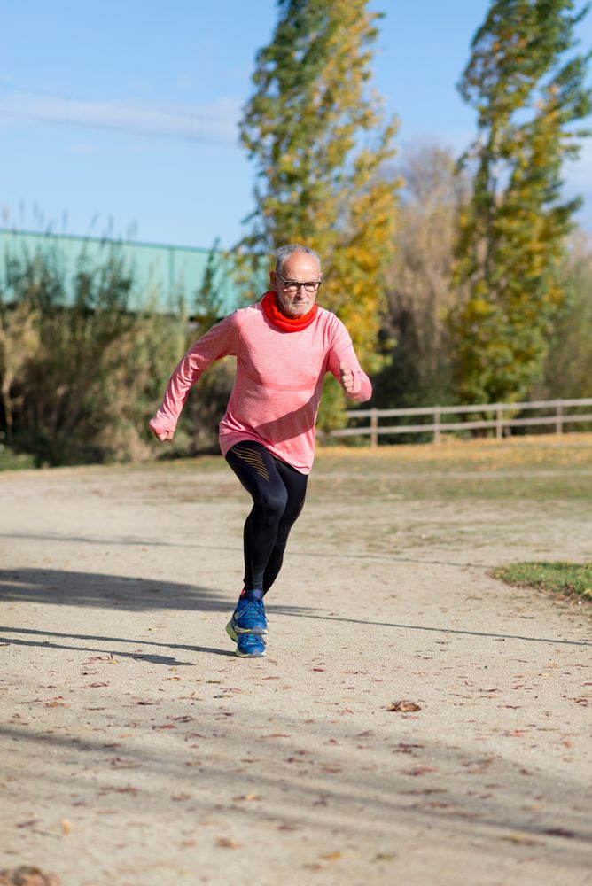 Older man sprinting in park