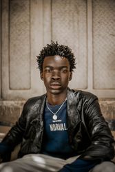 Young man in leather jacket sitting on doorstep