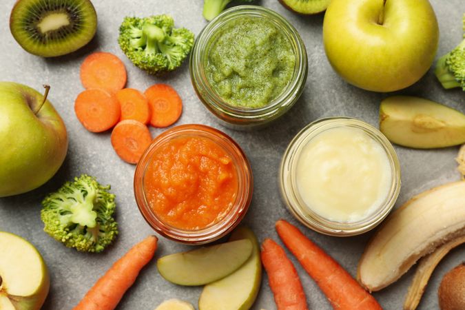 Composition with baby food on gray background, top view