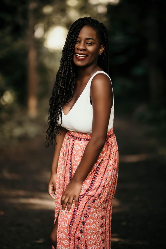 Young woman in light tank top and pink skirt smiling