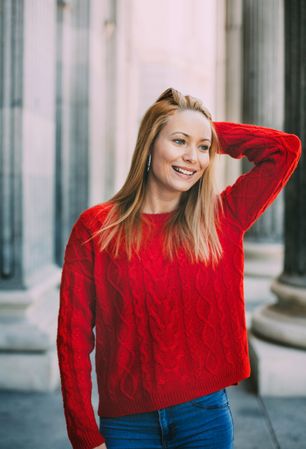 Stylish female standing near marble columns
