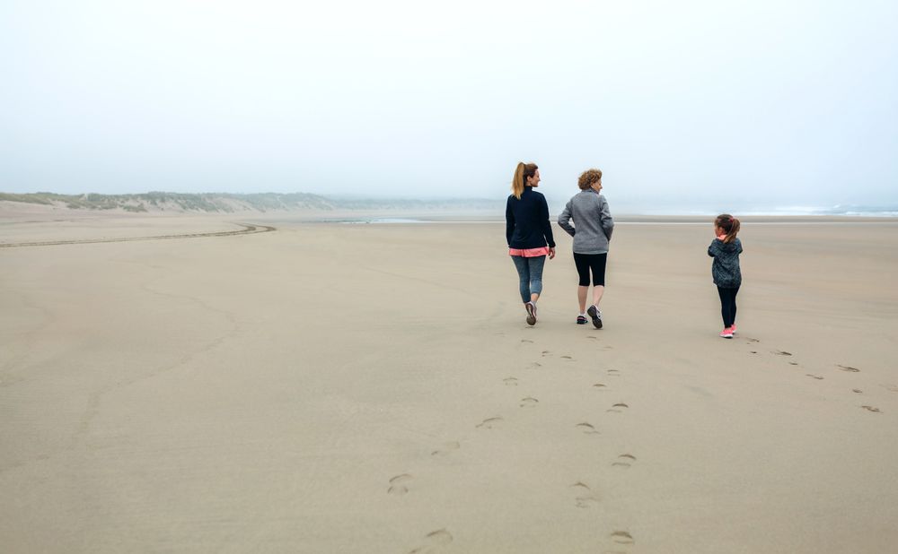 Three generations of women walking on the beach