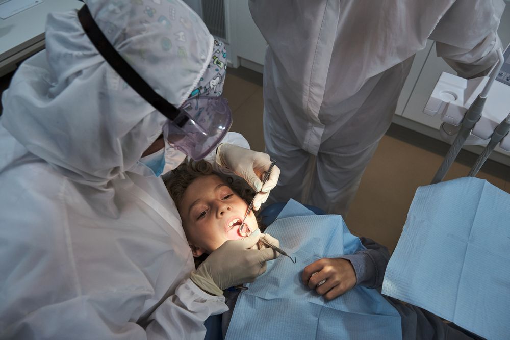 Dentists examining preteen patient in medical office