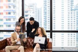 Group of cheerful businesspeople sitting on couch watching project on computer tablet 4Nekg5