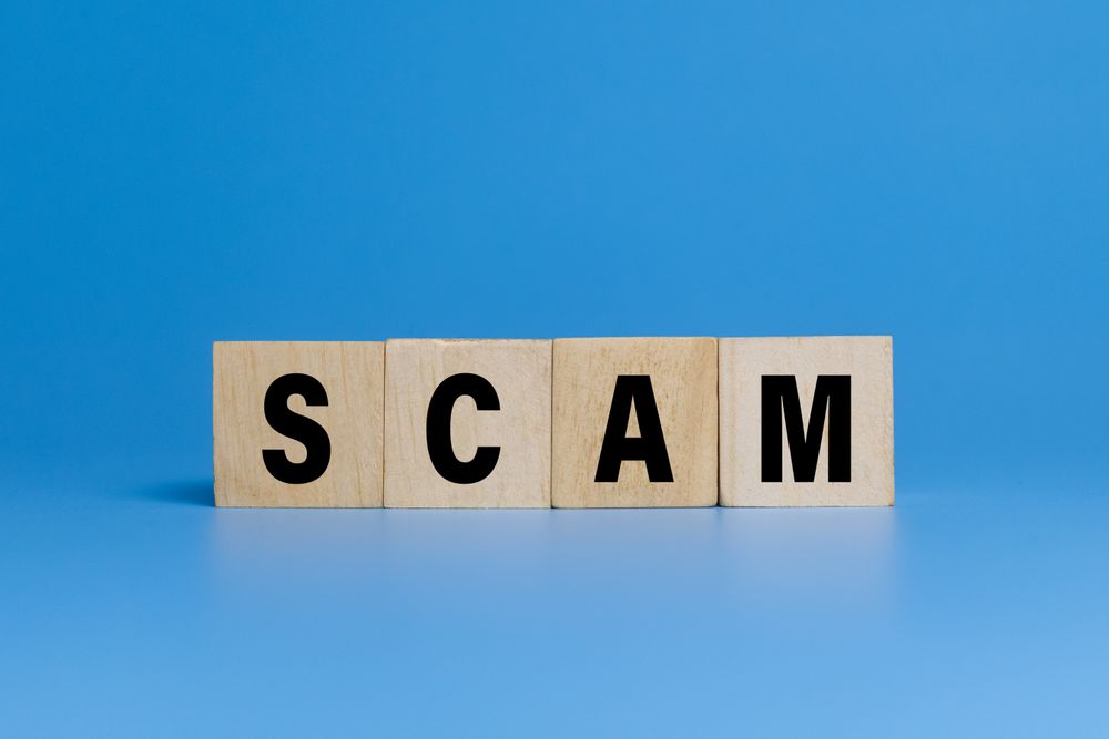 scam word text on wooden blocks isolated on blue background