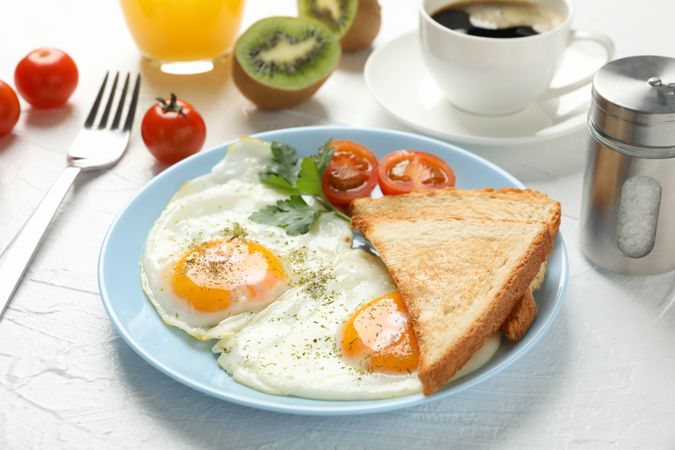 Plate of fried eggs for breakfast on blue plate