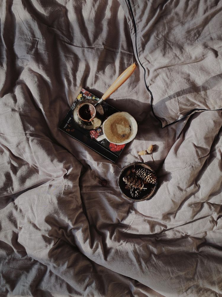 Top view of Turkish coffee on notebook on grey bedsheets
