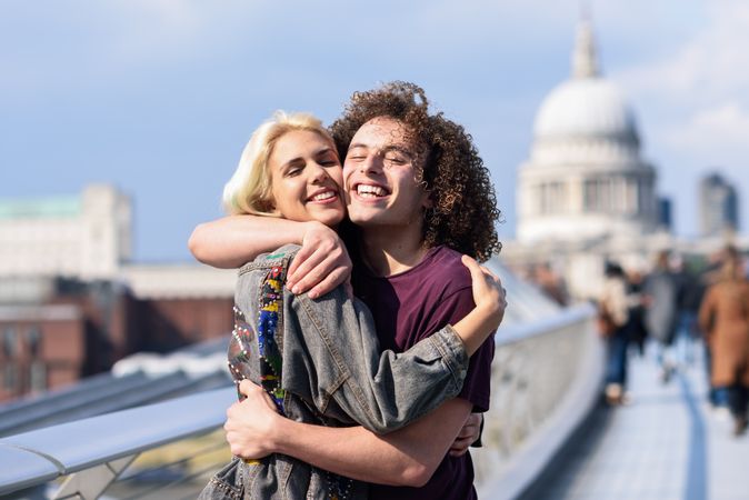 Blonde female and curly haired boyfriend on bridge in London