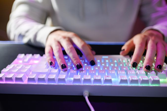 Unrecognizable person sitting with hand on keyboard