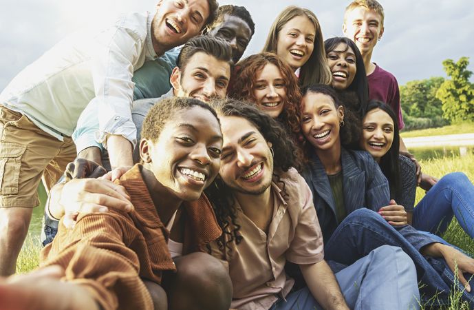 Cheerful international happy friends having fun taking selfies at picnic in the countryside