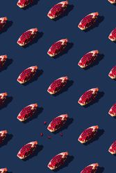 Pattern of pomegranate fruit slices on navy background