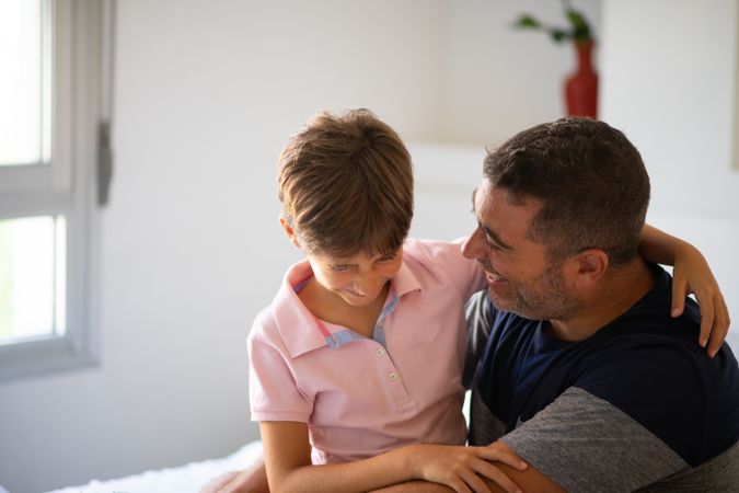 Little girl and dad hugging each other at home with copy space
