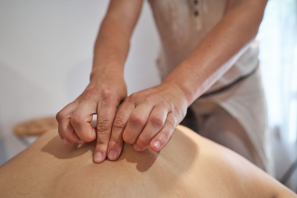 Crop woman kneading back of man