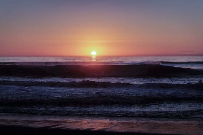 Waves in the Pacific Ocean as the sunsets at the horizon
