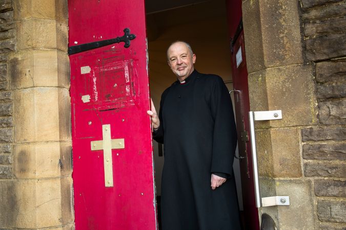 Vicar in door of parish