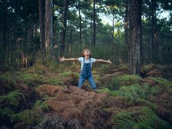 Excited boy playing in woods