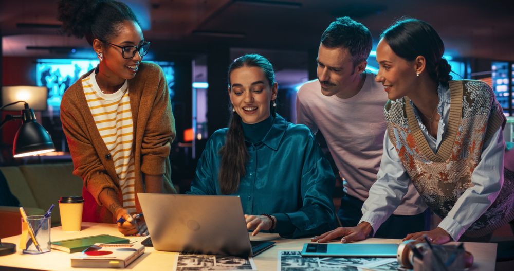 Multiethnic Group of People Use Laptop Computer to Discuss Work in Creative Office Conference Meeting Room.