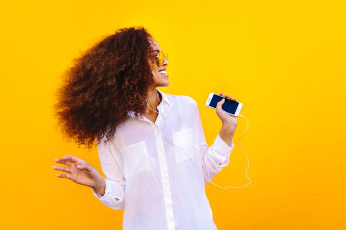 Young woman having fun while dancing to her music playlist
