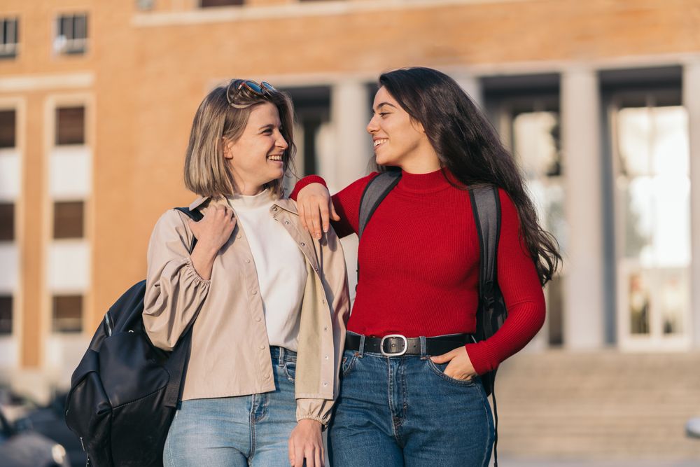 Two students portrait in college looking each other. Blonde and brunette
